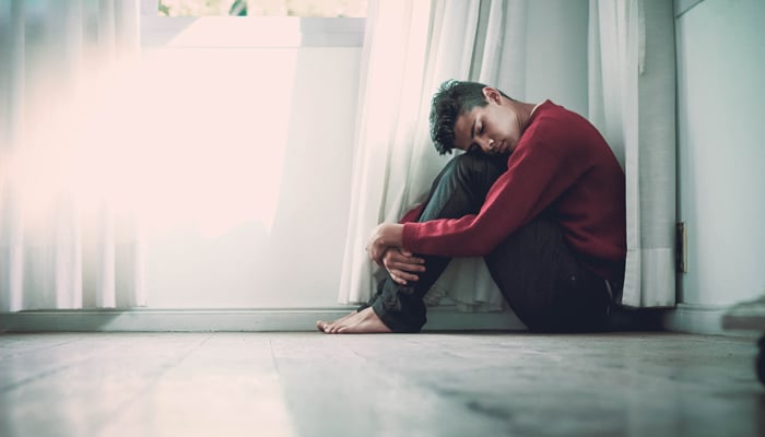 Man beside white frame window